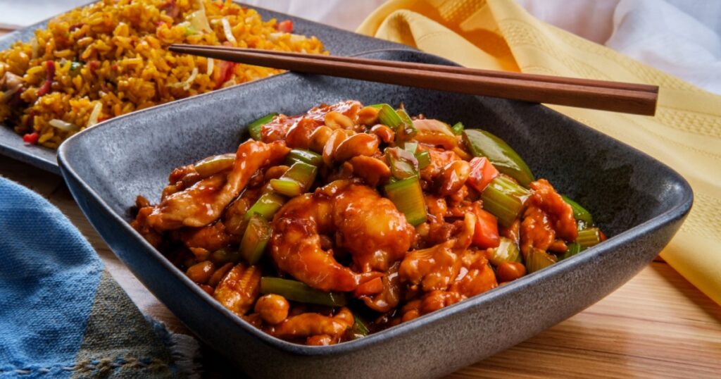 Takeout Chinese kung pao chicken and shrimp with peanuts and side of pork fried rice