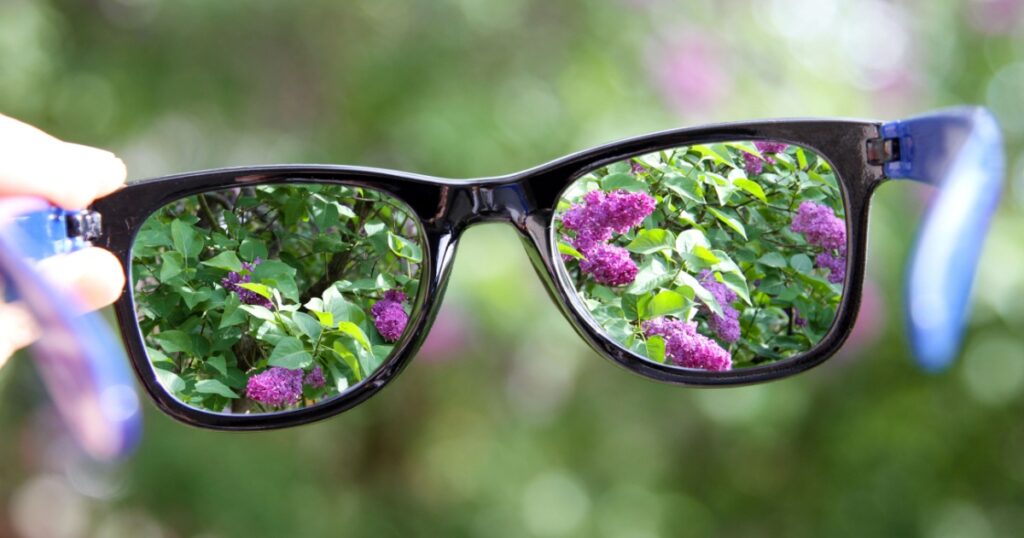 eyeglasses in the hand over blurred background