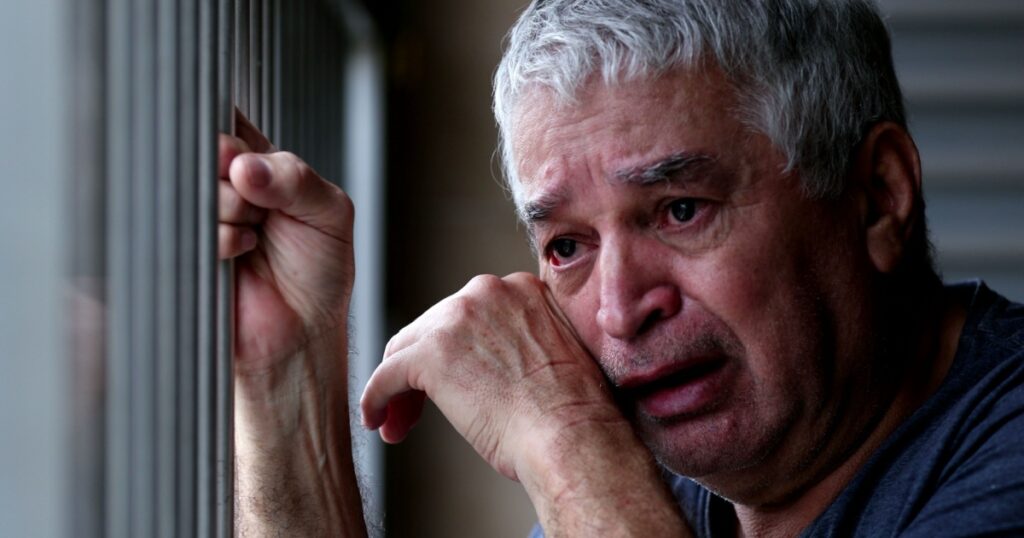 Older man crying with grief and pain. Senior person suffering alone
