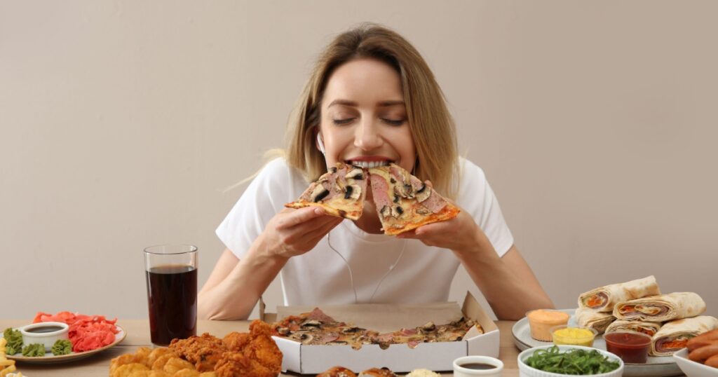 Food blogger eating at table against beige background. Mukbang vlog