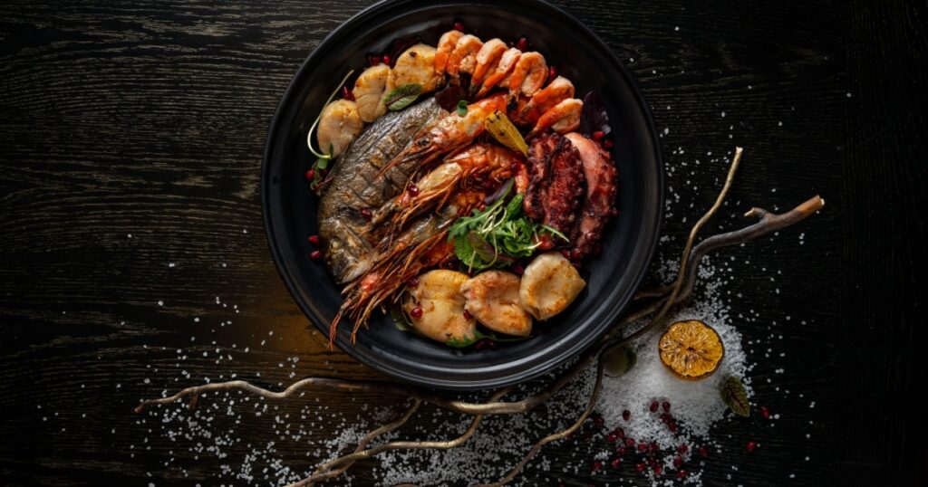 Mixed Seafood Contain Blue Crabs, Mussels, Big Shrimps, Calamari Squids and Grilled Barracuda Fish Garlic with Lemon on Dish
