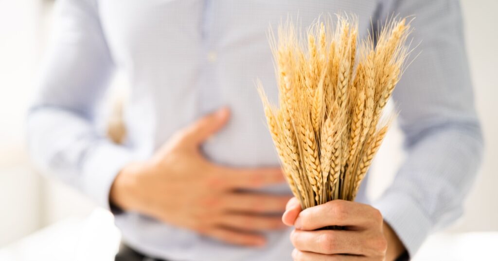 Celiac Disease And Gluten Intolerance. Women Holding Spikelet Of Wheat