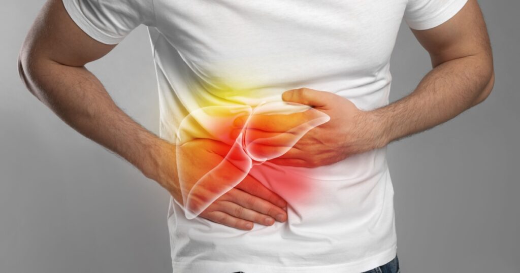 Man suffering from liver pain on grey background, closeup