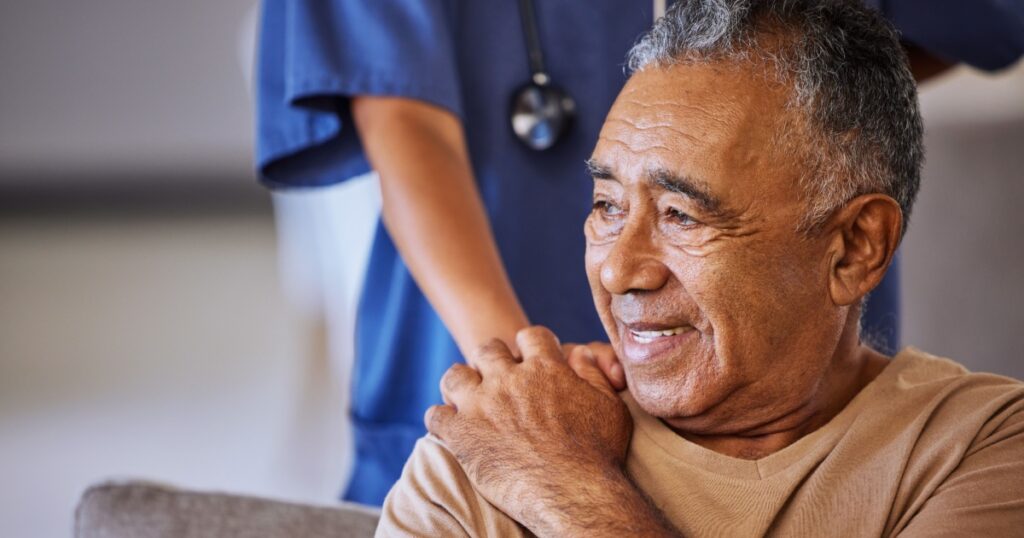 Nurse or doctor give man support during recovery or loss. Caregiver holding hand of her sad senior patient and showing kindness while doing a checkup at a retirement, old age home or hospital