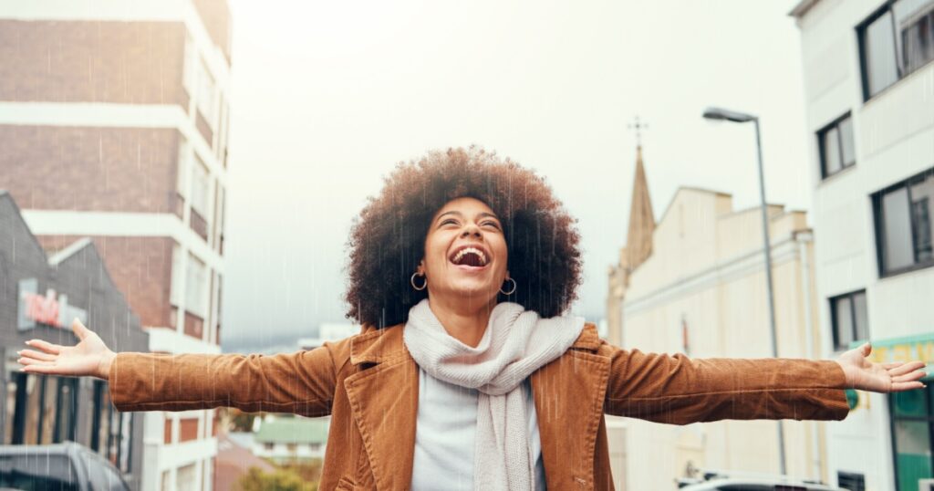 Smile, happy and black woman with gratitude in a city with freedom, success and inspiration outdoors. Hope, god and excited African girl with grateful open hands, abundance and positive mindset