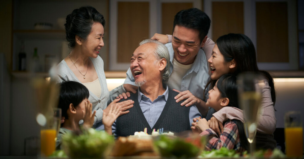 happy three generation asian family celebrating grandpa's birthday at home