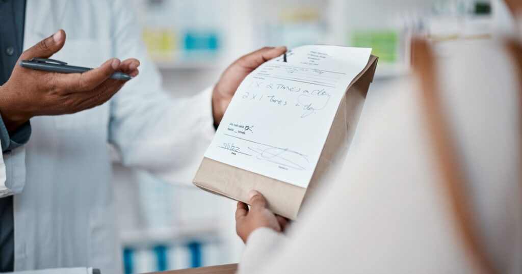 Healthcare, pharmacist hands with medicine for woman at counter buying prescription drugs at drug store. Health, wellness and medical insurance, man and customer at pharmacy for advice and pills.