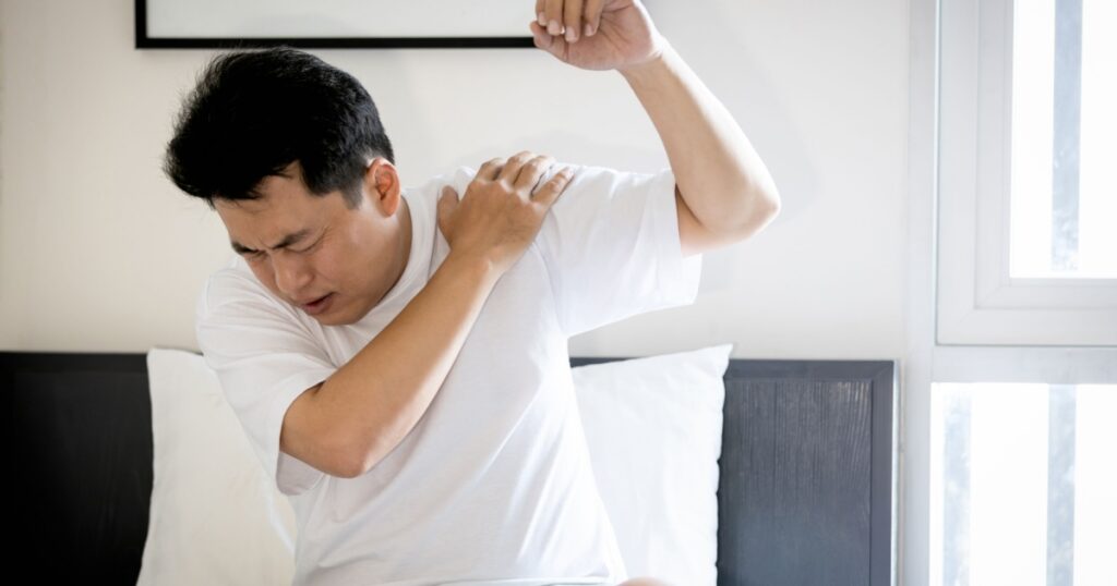 Asian middle aged man suffering from frozen shoulder,pain and stiffness,unable to move,difficulty lifting his arm,male people with calcific tendonitis or shoulder injuries,health care,medical concept