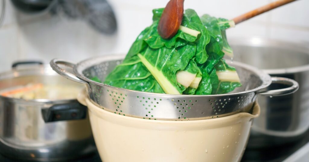 Preparing healthy lunch in the kitchen, blanching chard using kitchen utensils