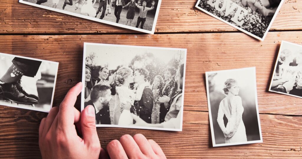 Wedding photos laid on a table. Studio shot on wooden background.