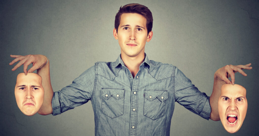 Smiling man holding two different face emotion masks