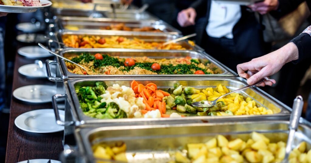 Cuisine Culinary Buffet Dinner Catering Dining Food Celebration Party Concept. Group of people in all you can eat catering buffet food indoor in luxury restaurant with meat and vegetables.