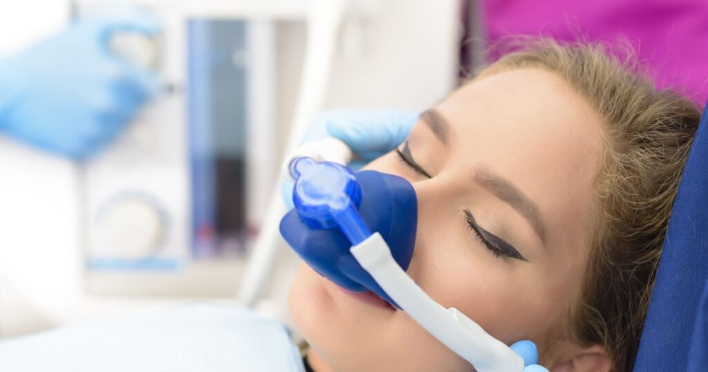 Beautiful getting woman inhalation sedation at dental clinic