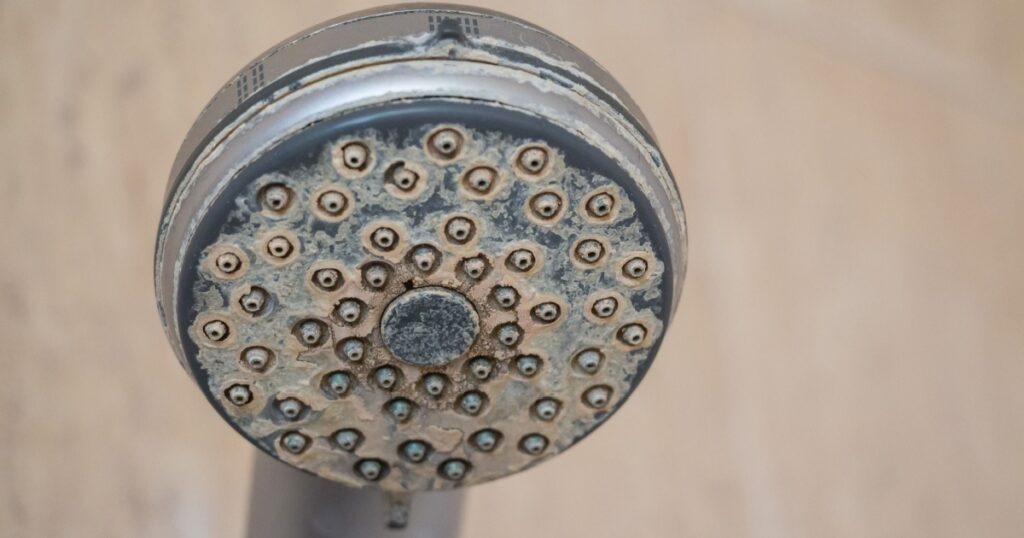 Hard water deposit and rust on shower tap
