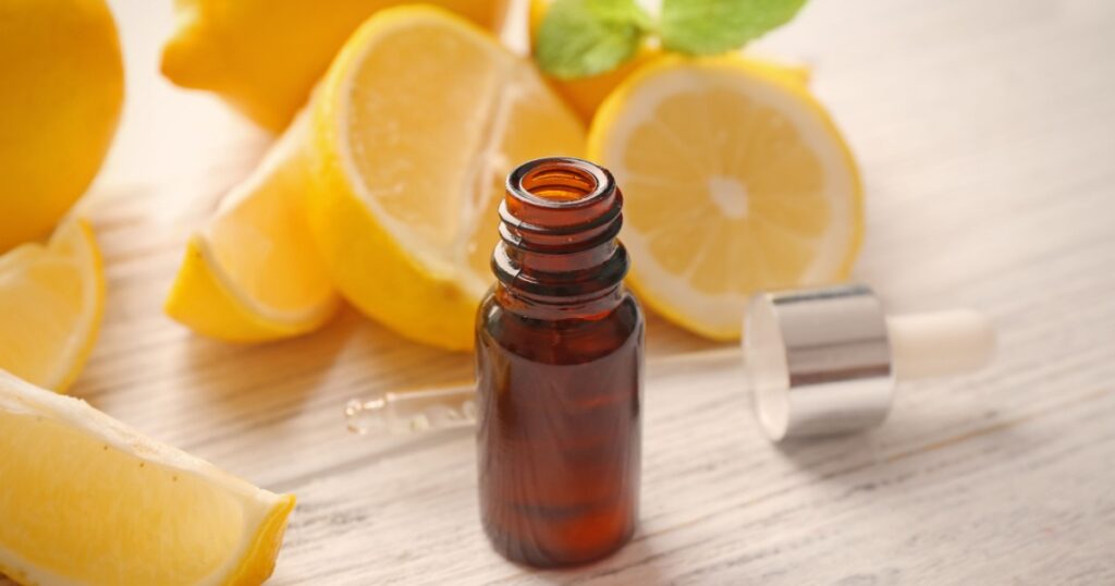 Beautiful spa composition with lemon essential oil on white wooden background, closeup