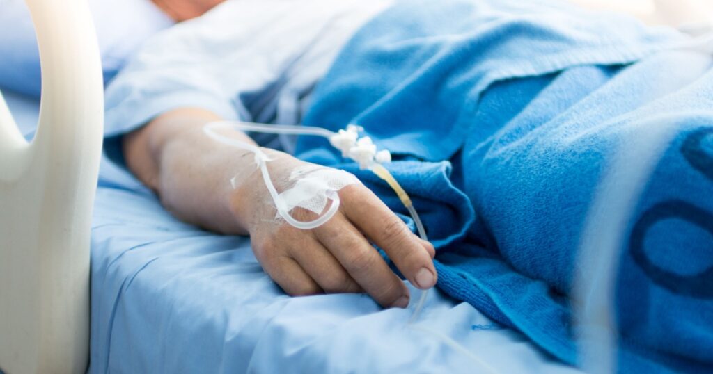 Focus on the hand of a patient in hospital ward