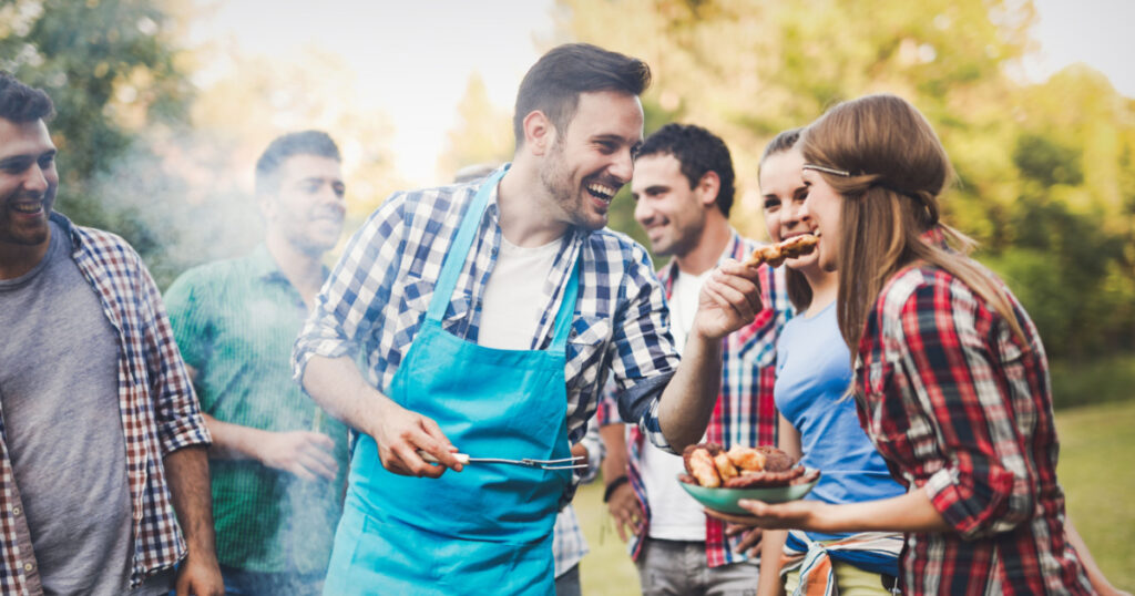 Friends having a barbecue party in nature while having a blast