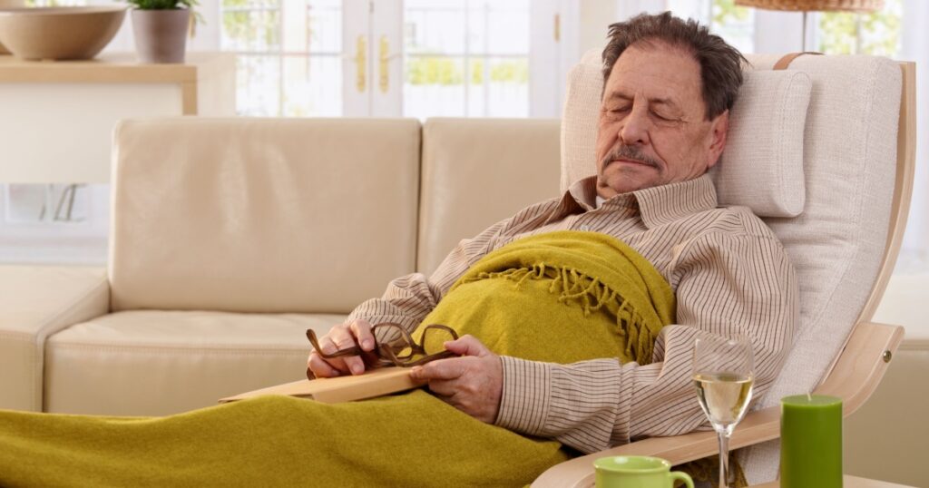Senior man napping in armchair at home.?
