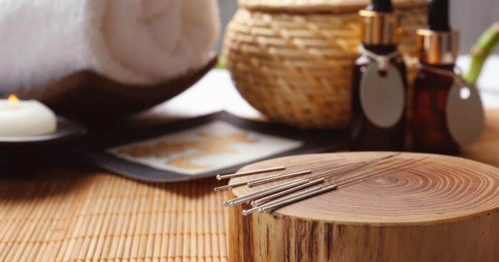 Composition with acupuncture needles on bamboo mat