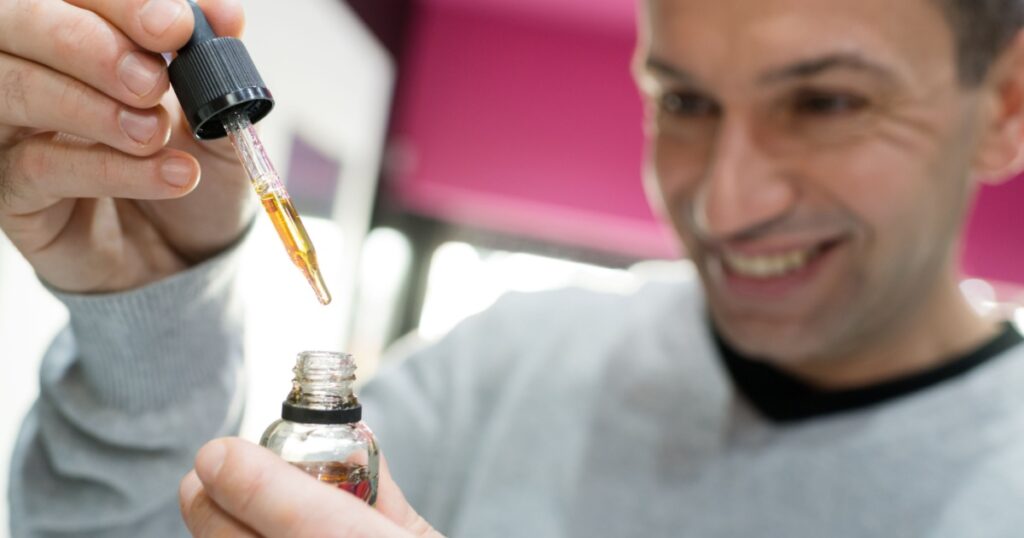 man holding a medical brown drop bottle