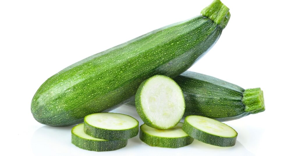 fresh green zucchini with slice isolated on white background