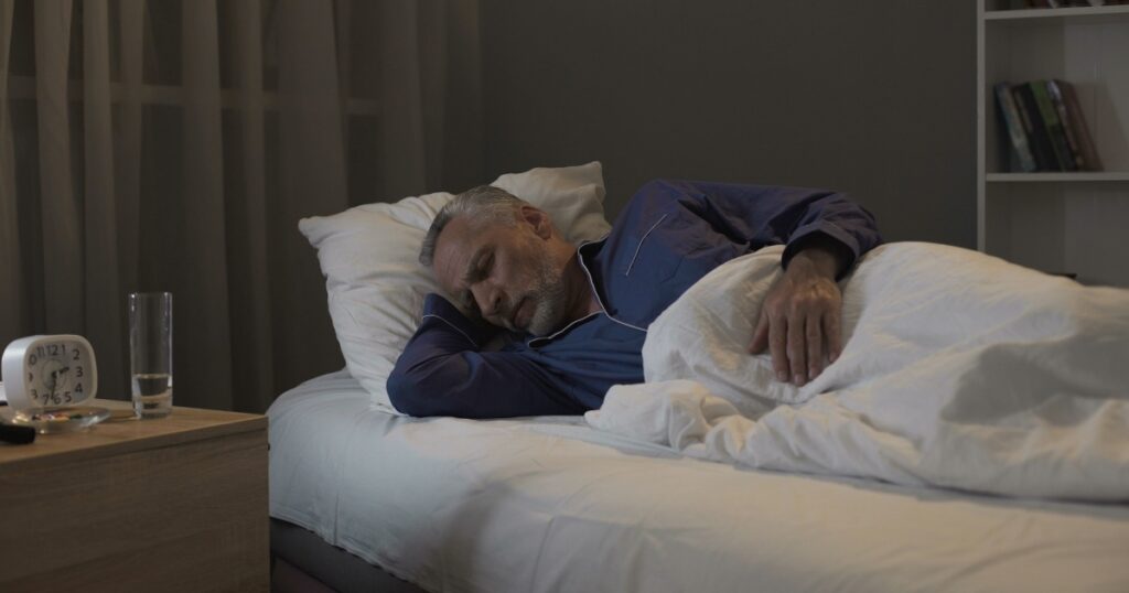 Retired man seeing nightmares in his dreams, sleeping in ward of nursing home