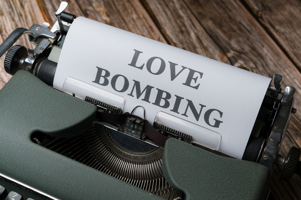 type writer with paper that says 'love bombing'