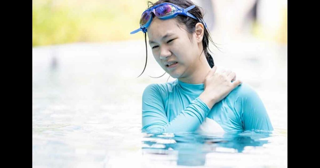 Asian teen girl having itchy or irritated skin,dry skin problem,scratching her body in swimming pool,young woman in swimsuit has an allergic reaction to chlorine in water,sensitive skin,health care