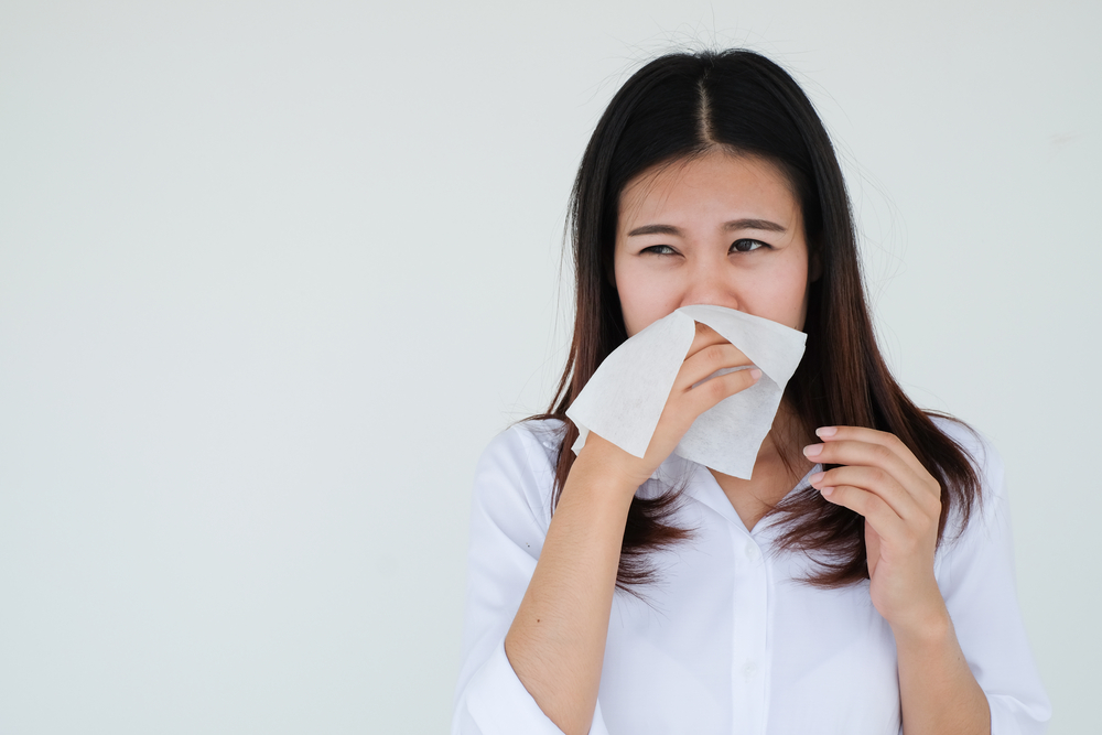 close up asian woman holding tissue in hand for reaction sneezing after got coronavirus disease for unhealthy life and protection coronavirus (covid 19) infection concept
