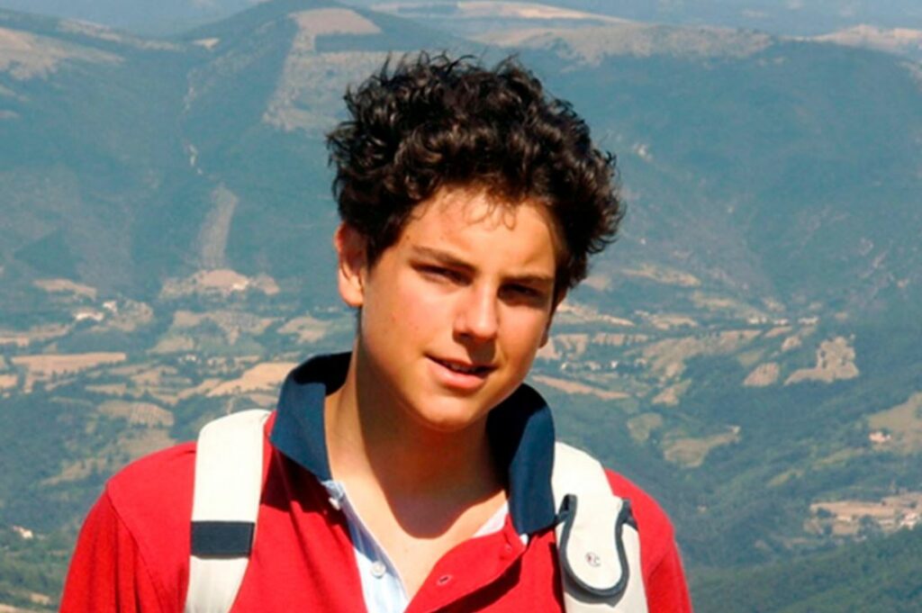Carlo stands in front of a mountainous background.