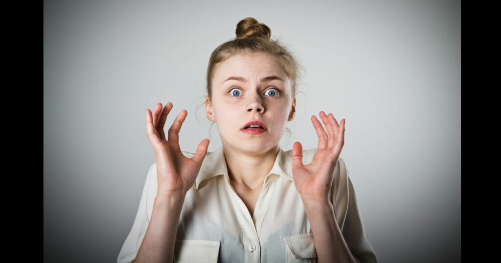 A Young slim woman is taken aback by something. Fear concept.