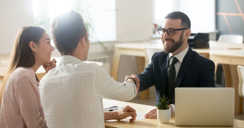 Smiling lawyer, realtor or financial advisor handshaking young couple thanking for advice, insurance broker or bank worker and millennial customers shake hands making deal, investment or taking loan
