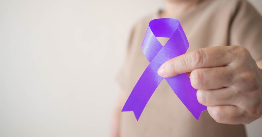 Elderly woman holding purple ribbon awareness w/ copy space. Symbol is used to raise awareness for Alzheimer's disease, elder abuse, epilepsy, pancreatic cancer, thyroid cancer and lupus. Close up.