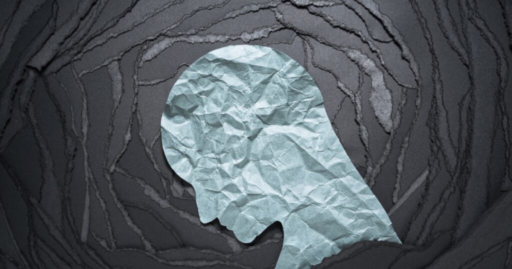 Silhouette of depressed and anxiety person head. Negative emotion image. Person head shaped paper on black torn paper background.