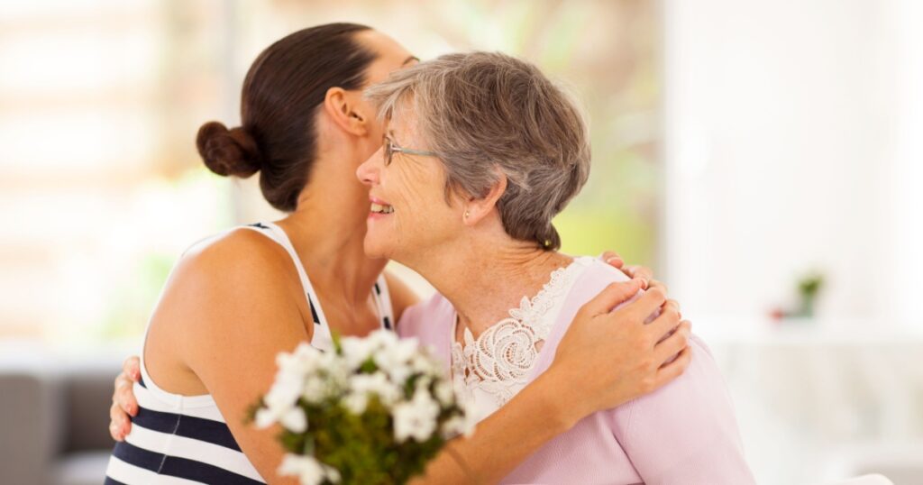 young woman hugging senior mother when visiting her