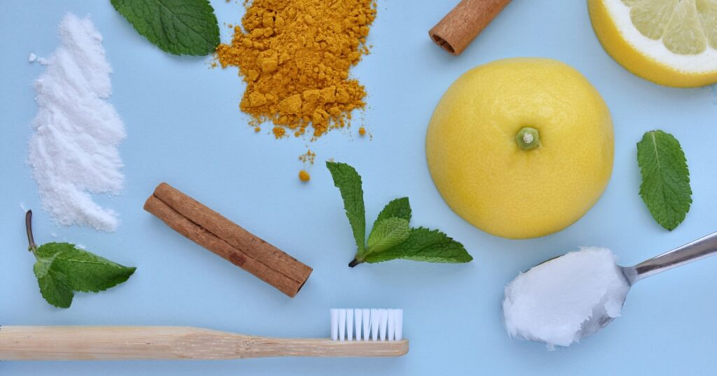 Natural organic ingredients for homemade toothpaste, eco friendly bamboo toothbrush, creative flat lay on blue background, natural oral hygiene.