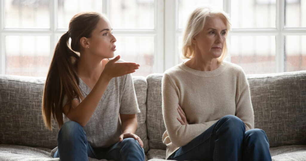 Annoyed grown up daughter expressing complaints to elderly mother annoyed females sit on couch, old stubborn mom dont want make concessions, different ages, generational gap, family conflict concept