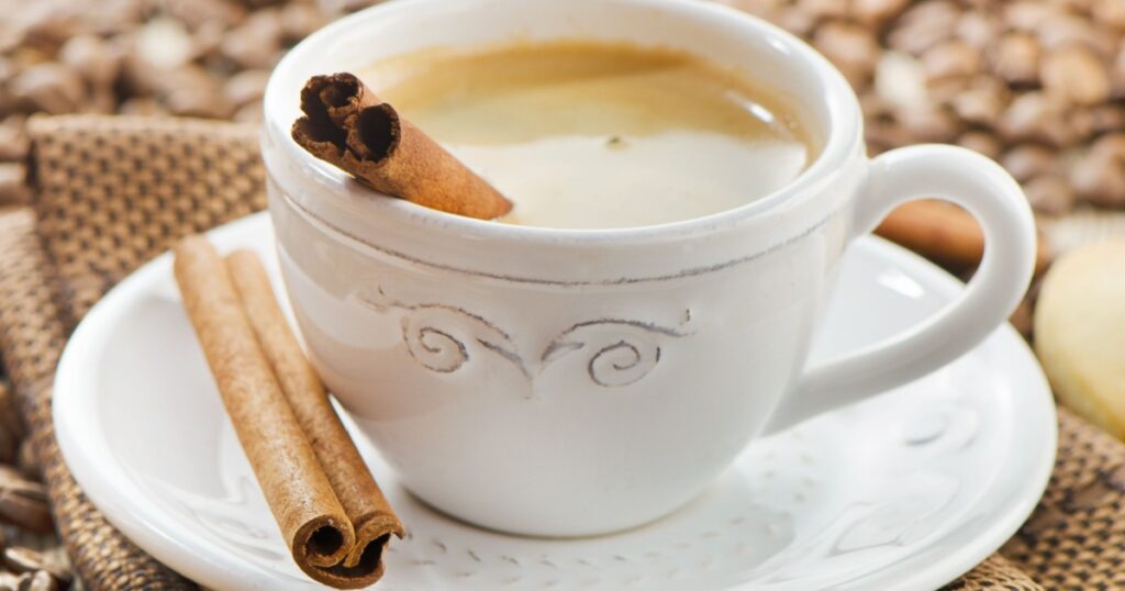 Cup of espresso with spices on a wooden table. Selective focus
