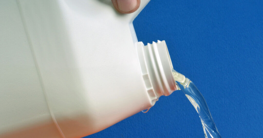 Pour bleach in closeup on blue background