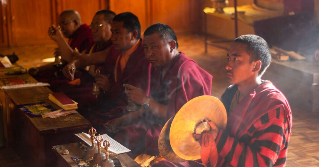 Kaza, Himachal Pradesh, India - May 2012: A novice Buddhist monk with large bronze cymbals in his hands at a traditional ceremony inside the ancient monastery at Kaza in the Spiti Valley.