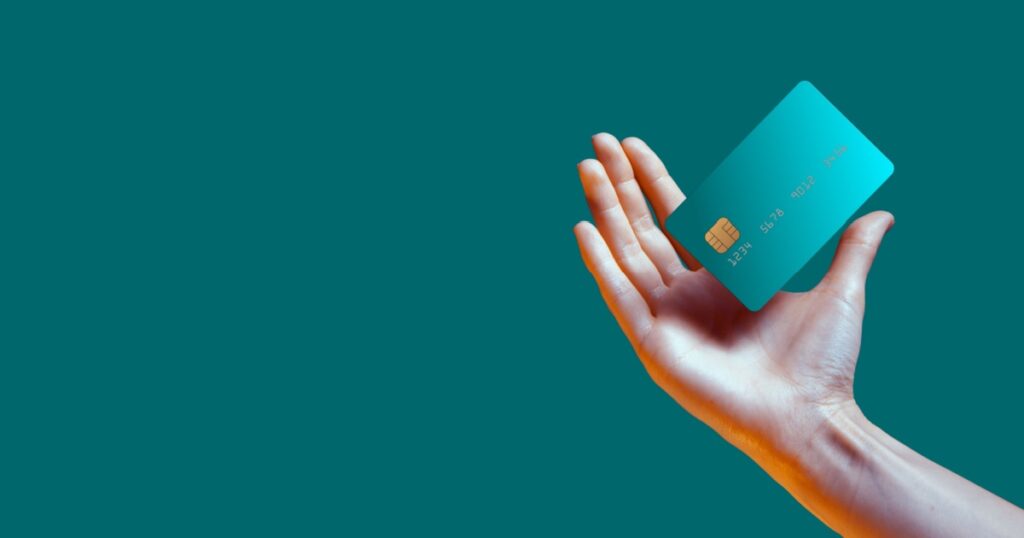 Close up female hand holds levitating template mockup Bank credit card with online service isolated on green background