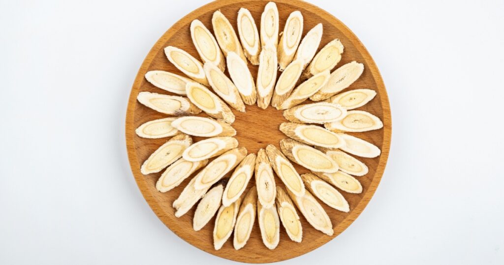 Astragalus membranaceus tablets on a plate on white background
