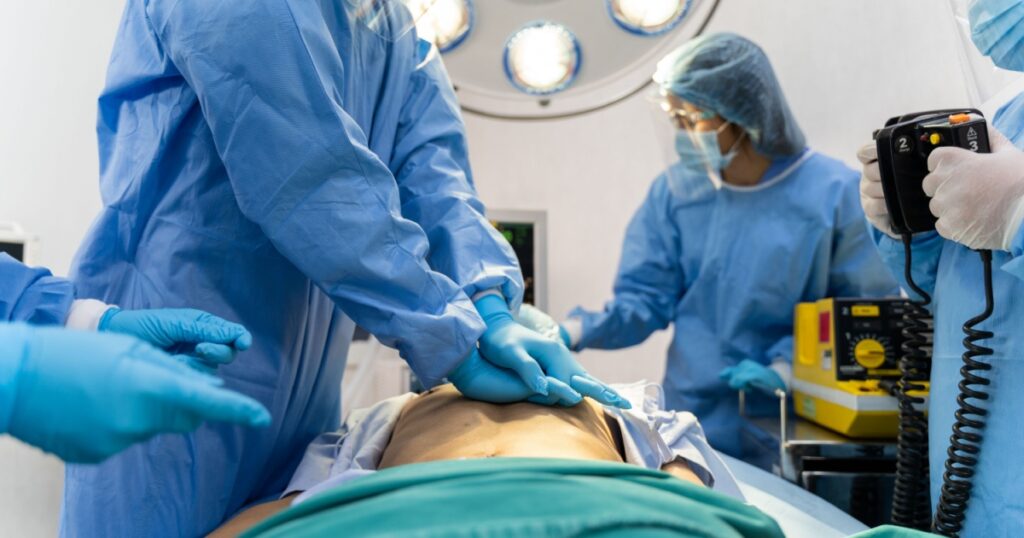 Medical team in Surgical gown help patient to making CPR Cardio Pulmonary Resuscitation in the operation room in hospital