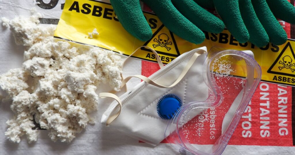 Close up asbestos, fibers, mask, filter, gloves and goggles. Bag in background. Barrier tape, warning forbidden acces, hazard. Asbestos removal. Asbestosis, lungcancer, mesothelioma. Protection