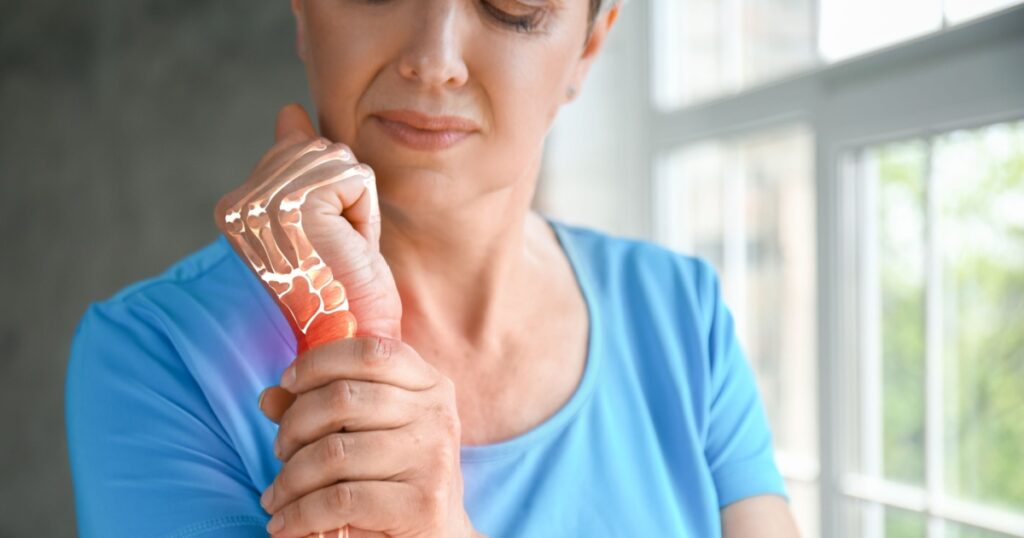 Mature woman having pain in wrist at home