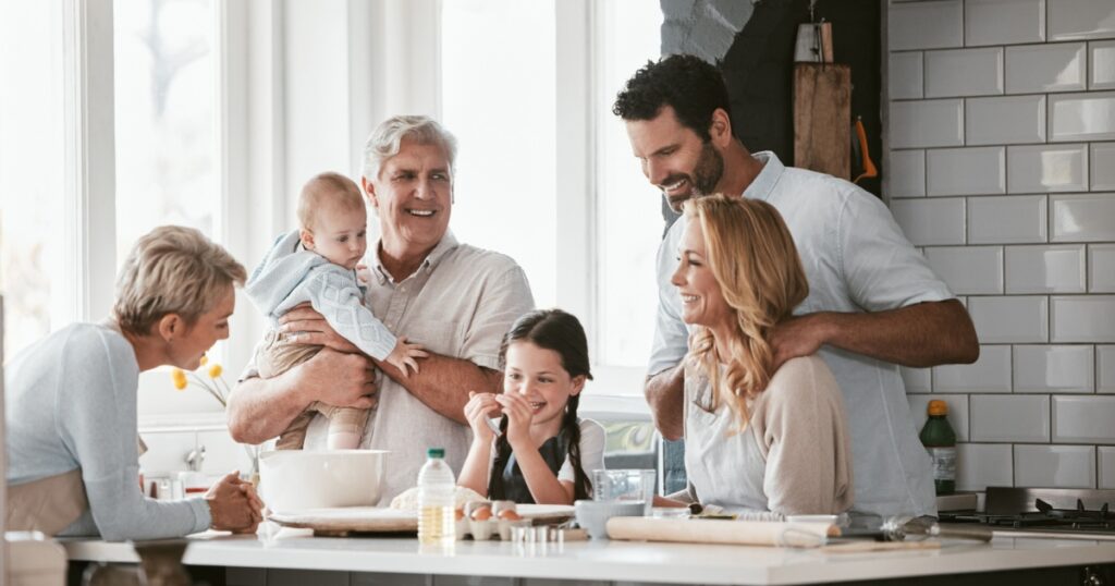 Big family, love and cooking in home kitchen, bonding or having fun. Support, care and grandparents, father and mother, baby and girl baking, learning and talking while enjoying quality time together