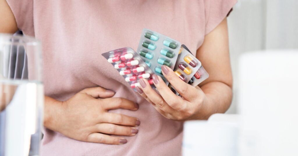 Antibiotic-associated diarrhea (AAD) concept with woman have an upset stomach, side effects from overusing antibiotics medicine often or long-term
