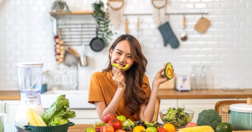 Portrait of beauty body slim healthy asian woman having fun hold avocado cooking preparing vegan food healthy eat with fresh vegetable salad, vegetarian in kitchen at home.Diet.Fitness, healthy food