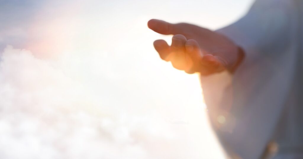 Jesus Christ with open arms reaching out in the sky, hand gestures of Jesus dying on the cross and resurrected, heaven and salvation, faith and love, easter concept