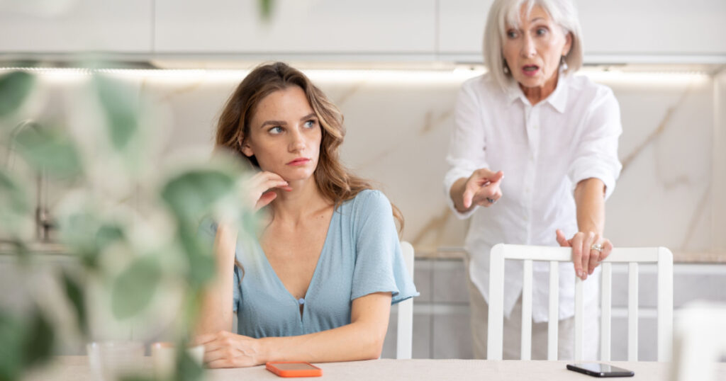 Elderly woman during family quarrel with adult woman in kitchen